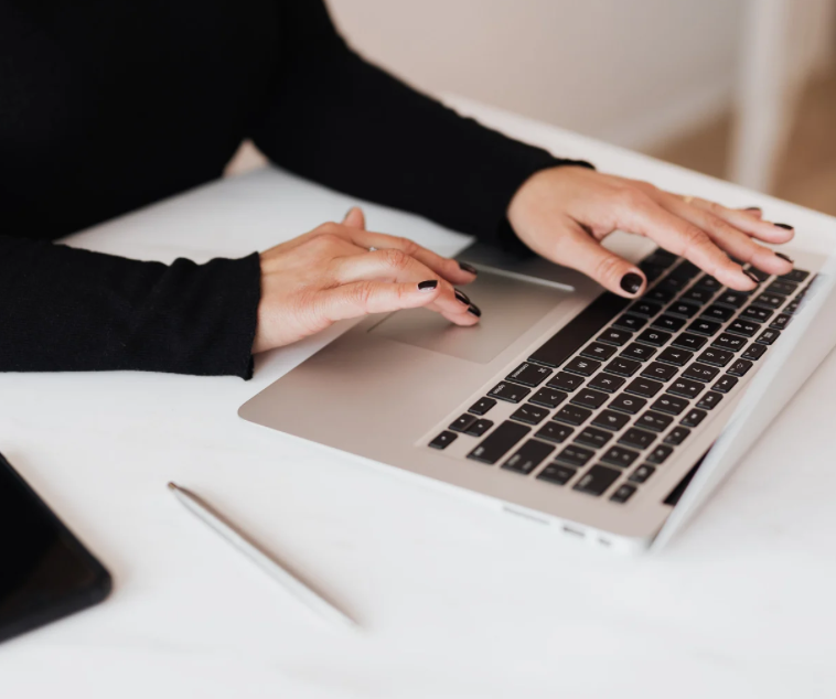 A scholar typing on a laptop, engaged in focused research work
